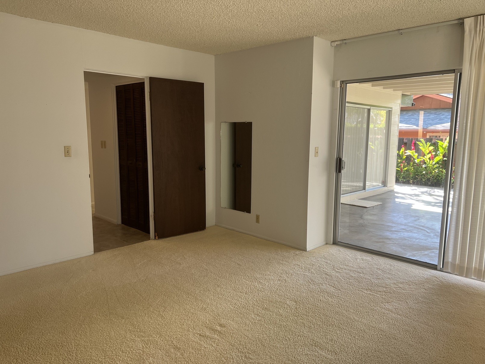 A room with a carpeted floor and two doors.